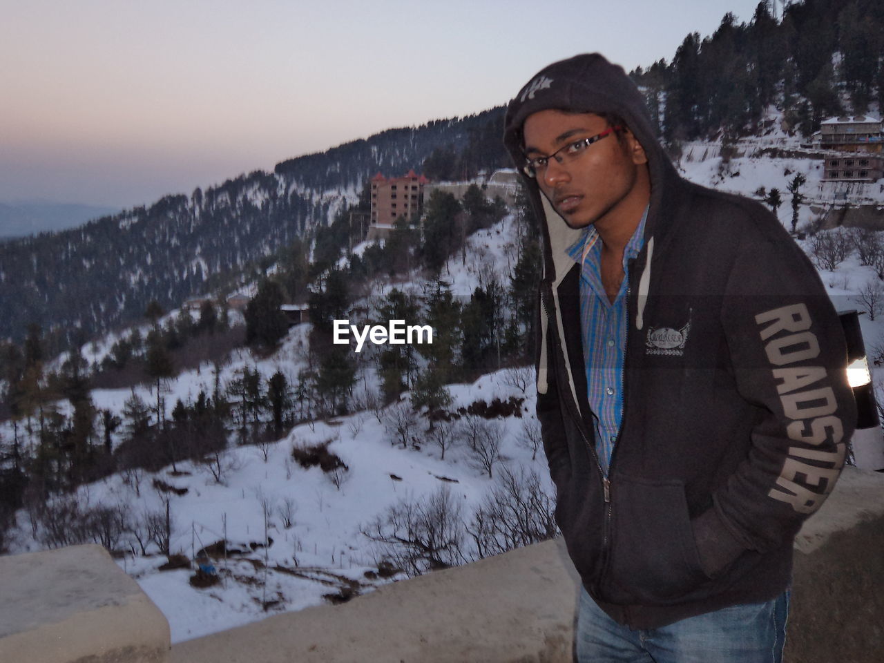 MAN WEARING SUNGLASSES STANDING IN SNOW