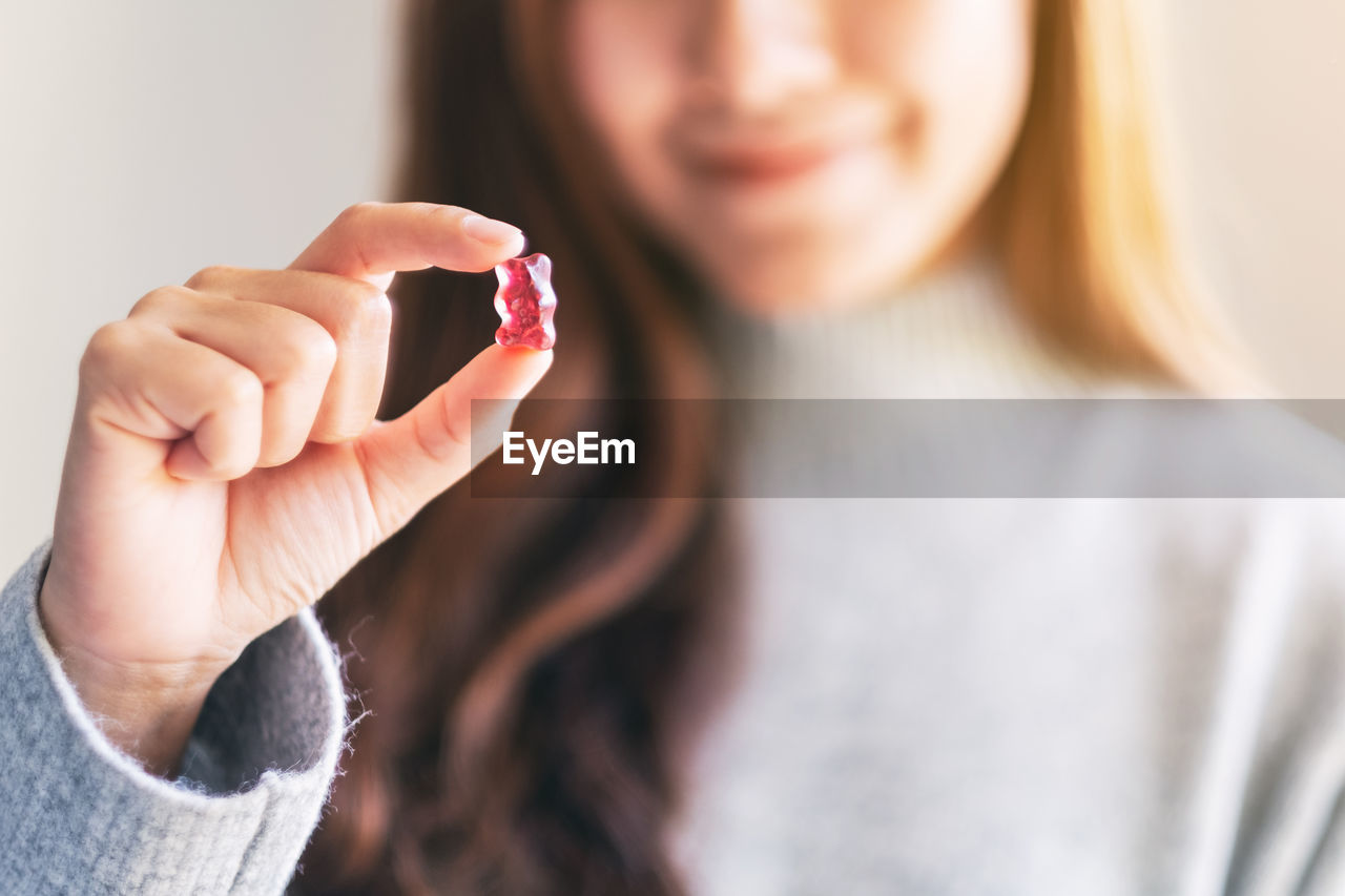 Midsection of woman holding candy