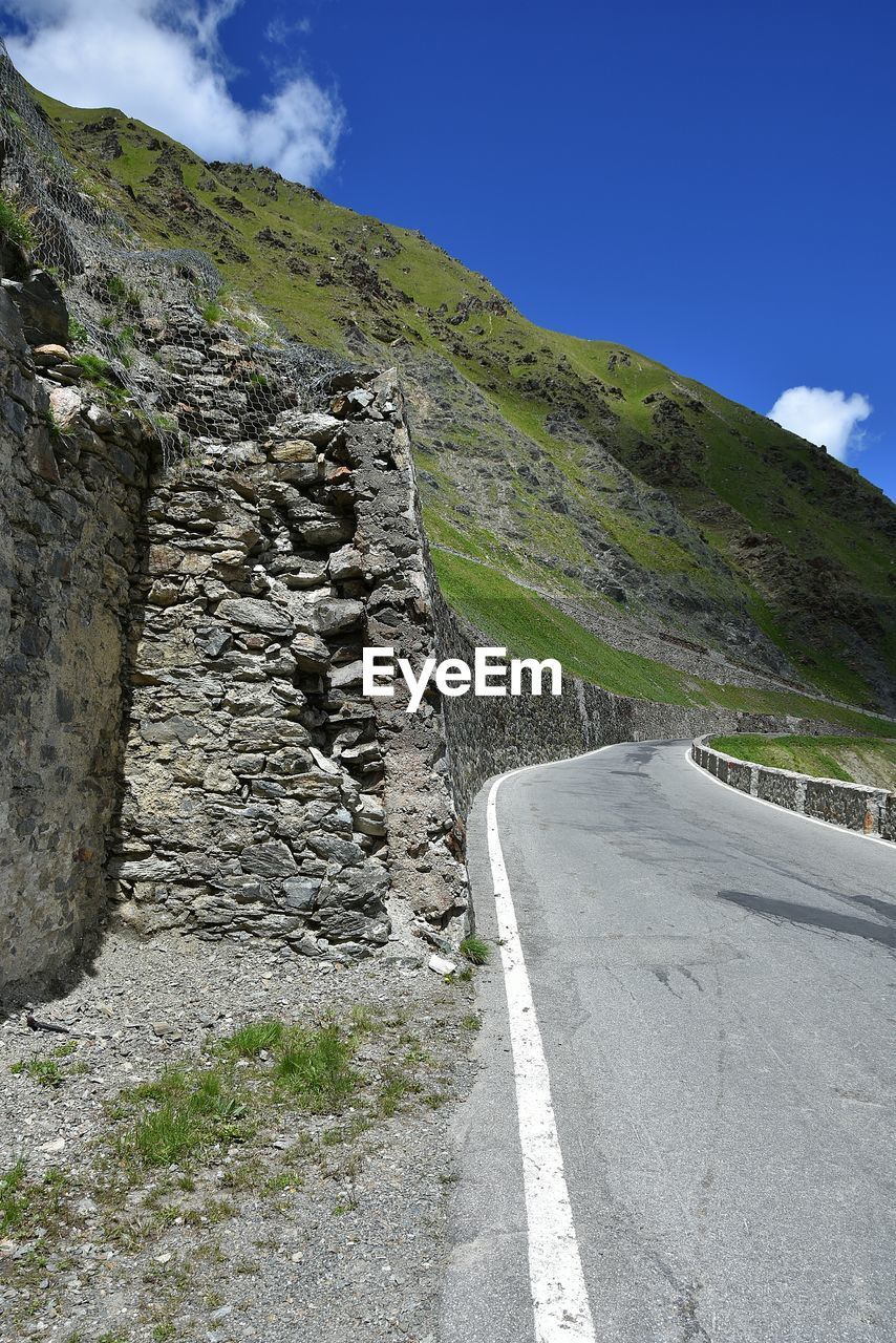 Road by mountain against sky