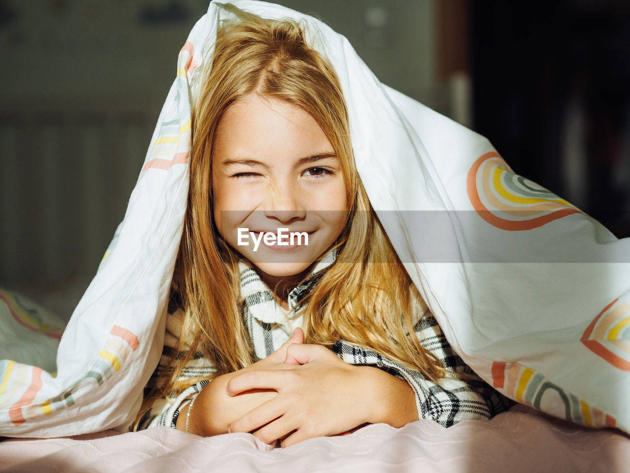 Portrait of girl lying on bed at home