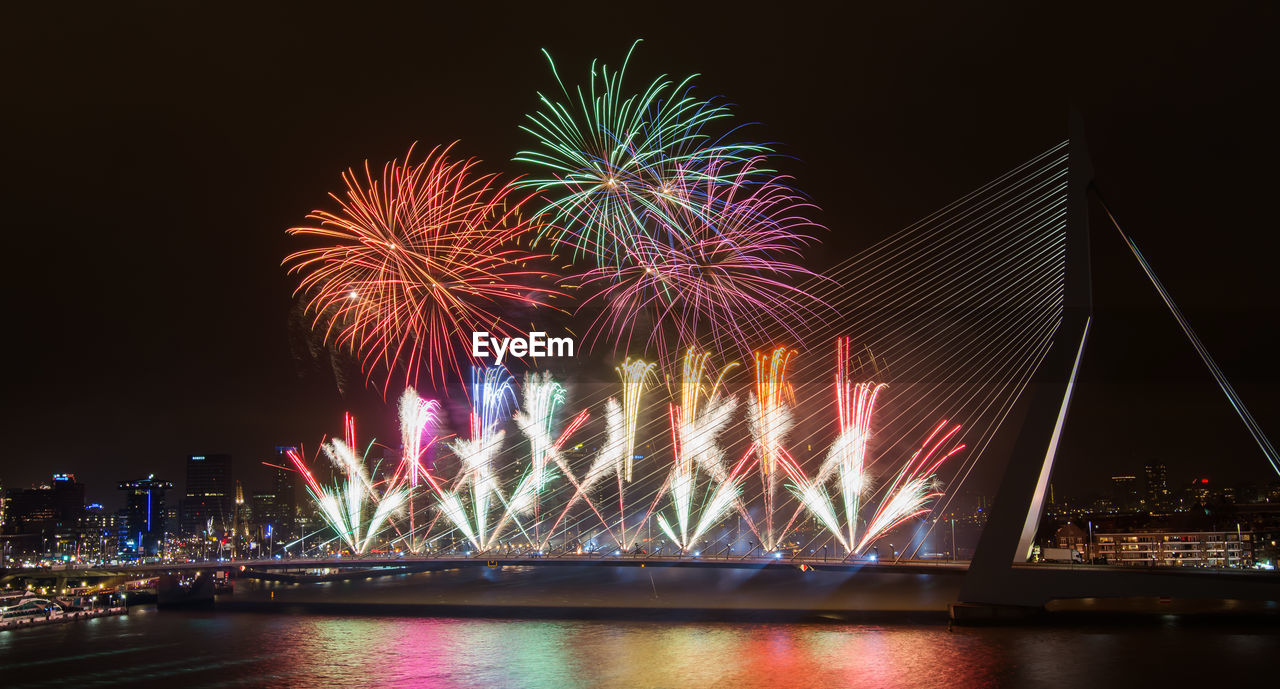 Firework exploding over erasmus bridge at night