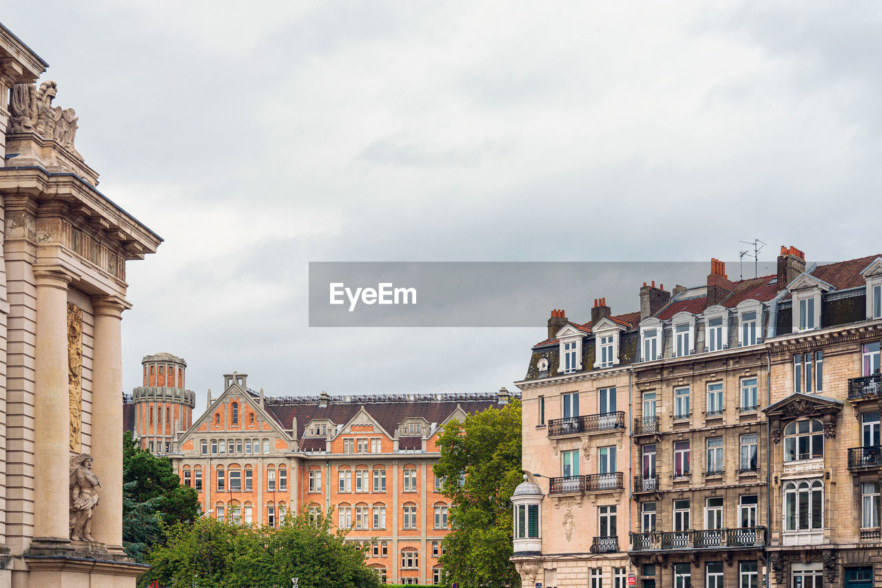 BUILDINGS IN CITY AGAINST CLOUDY SKY