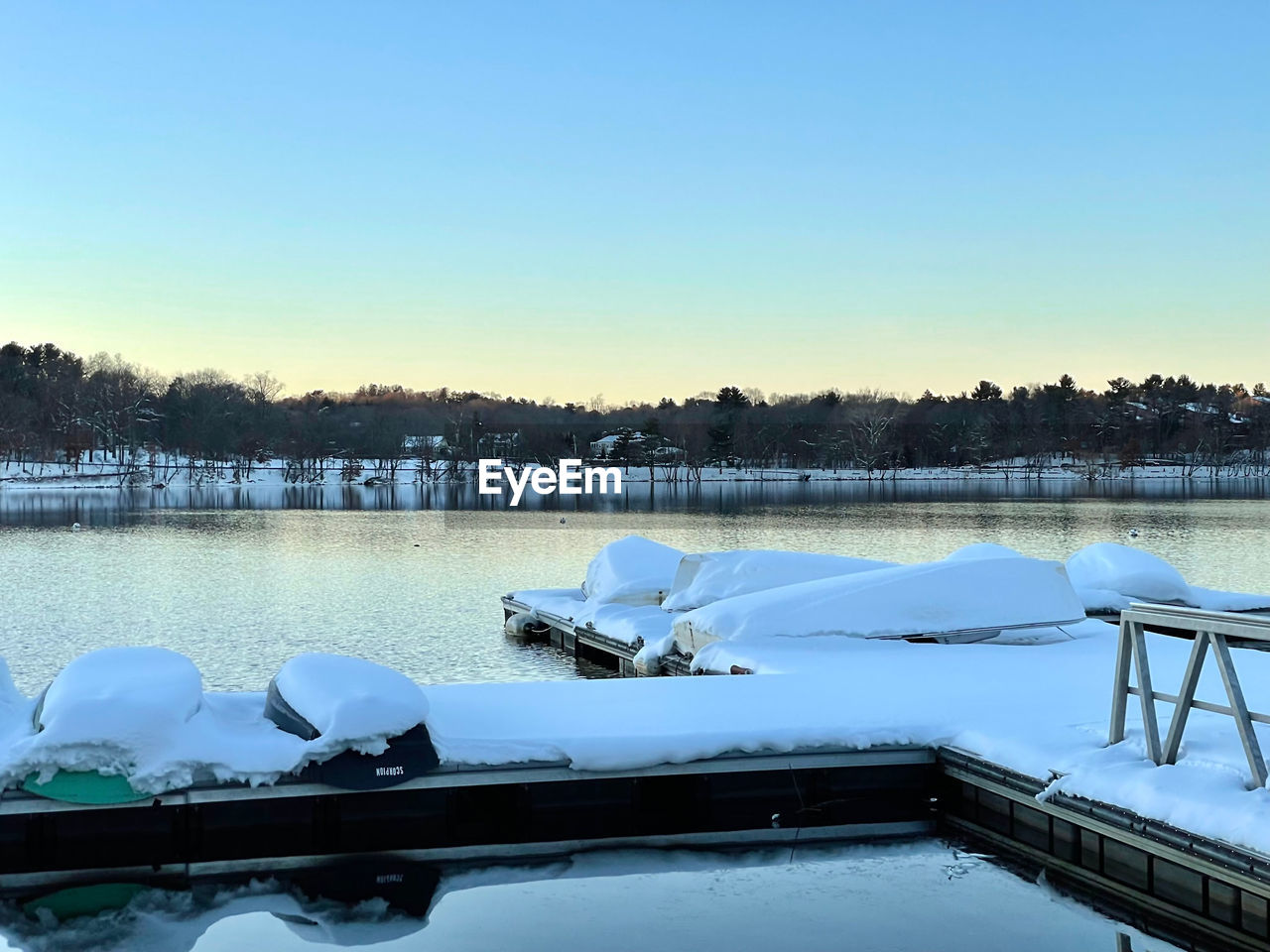 snow, water, cold temperature, winter, reflection, sky, nature, lake, frozen, tranquility, scenics - nature, no people, beauty in nature, tranquil scene, dock, clear sky, vehicle, blue, tree, ice, day, environment, travel destinations, copy space, non-urban scene, outdoors, boat, transportation, travel