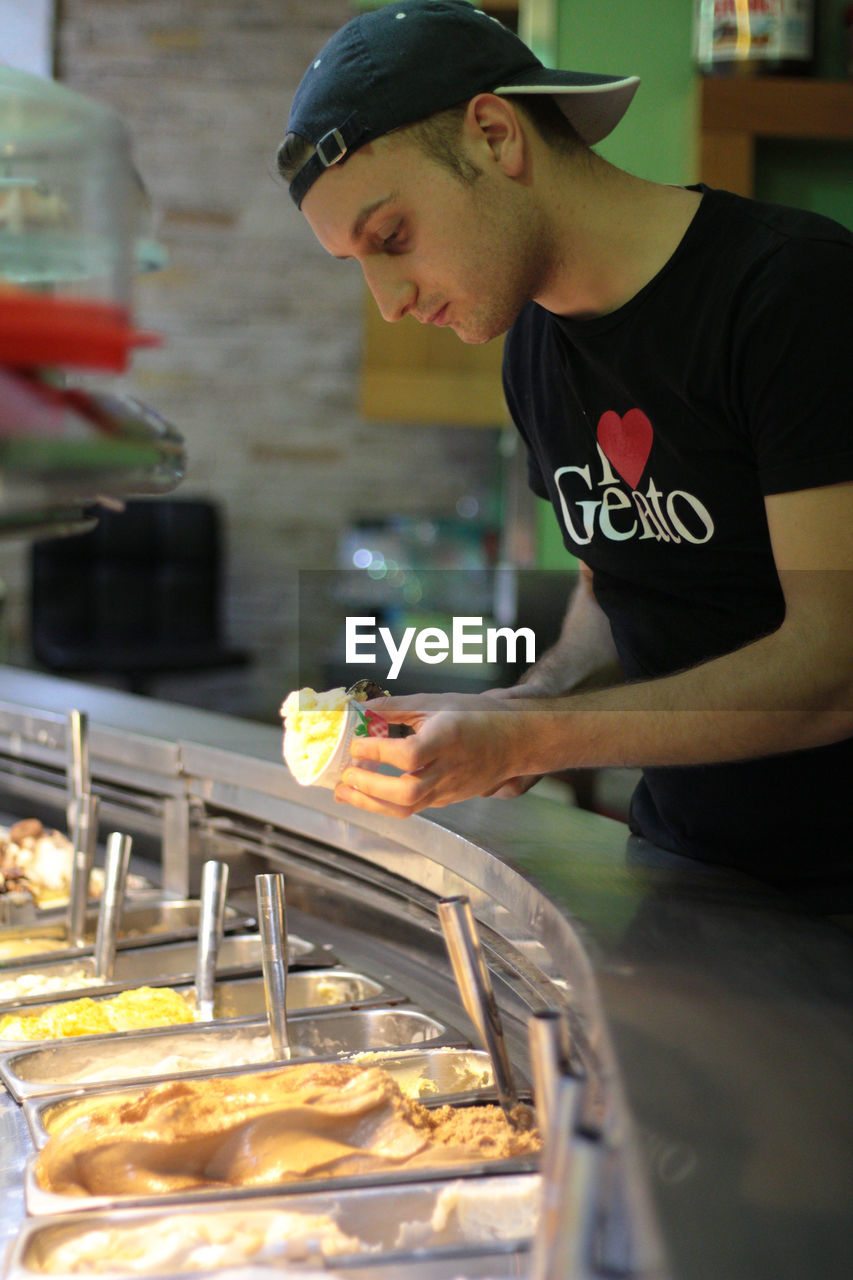 Man holding ice cream at parlor