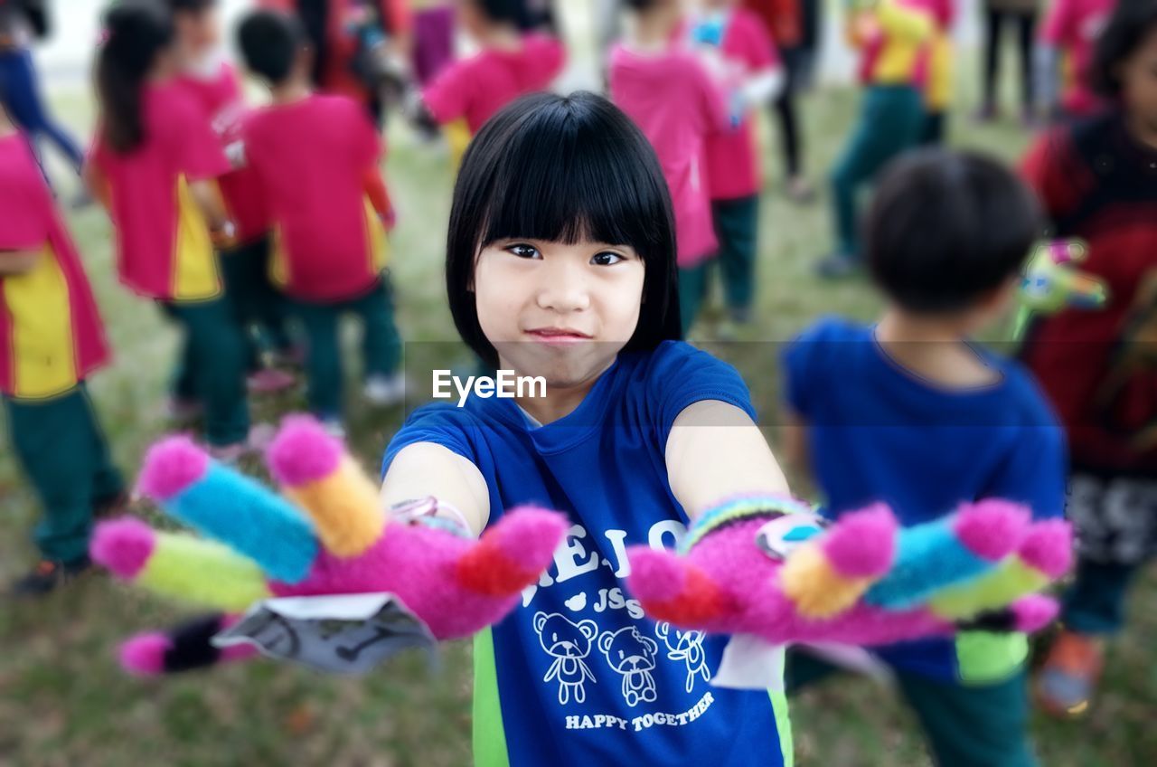 Portrait of smiling girl wearing multi colored gloves