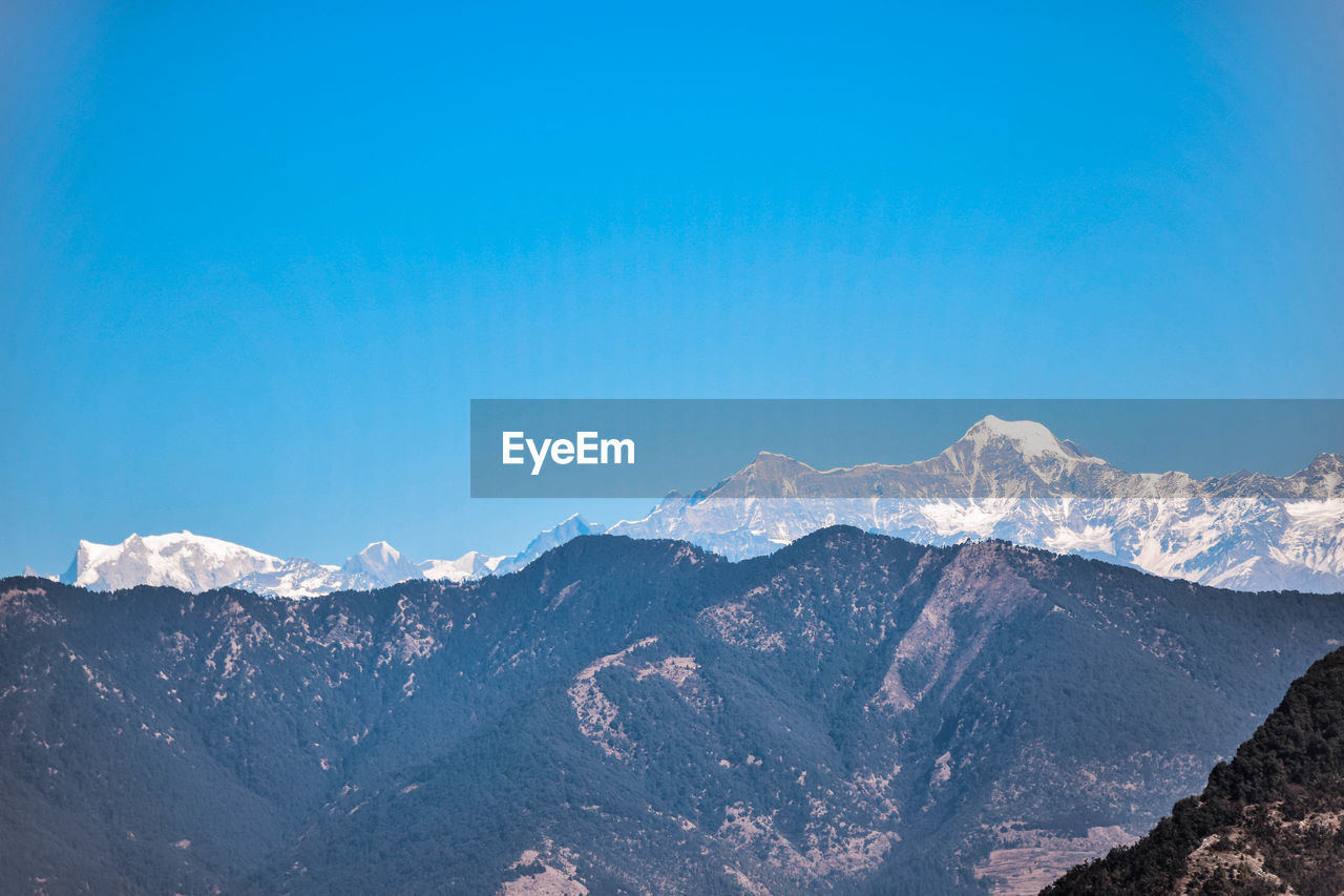 Scenic view of mountains against clear blue sky