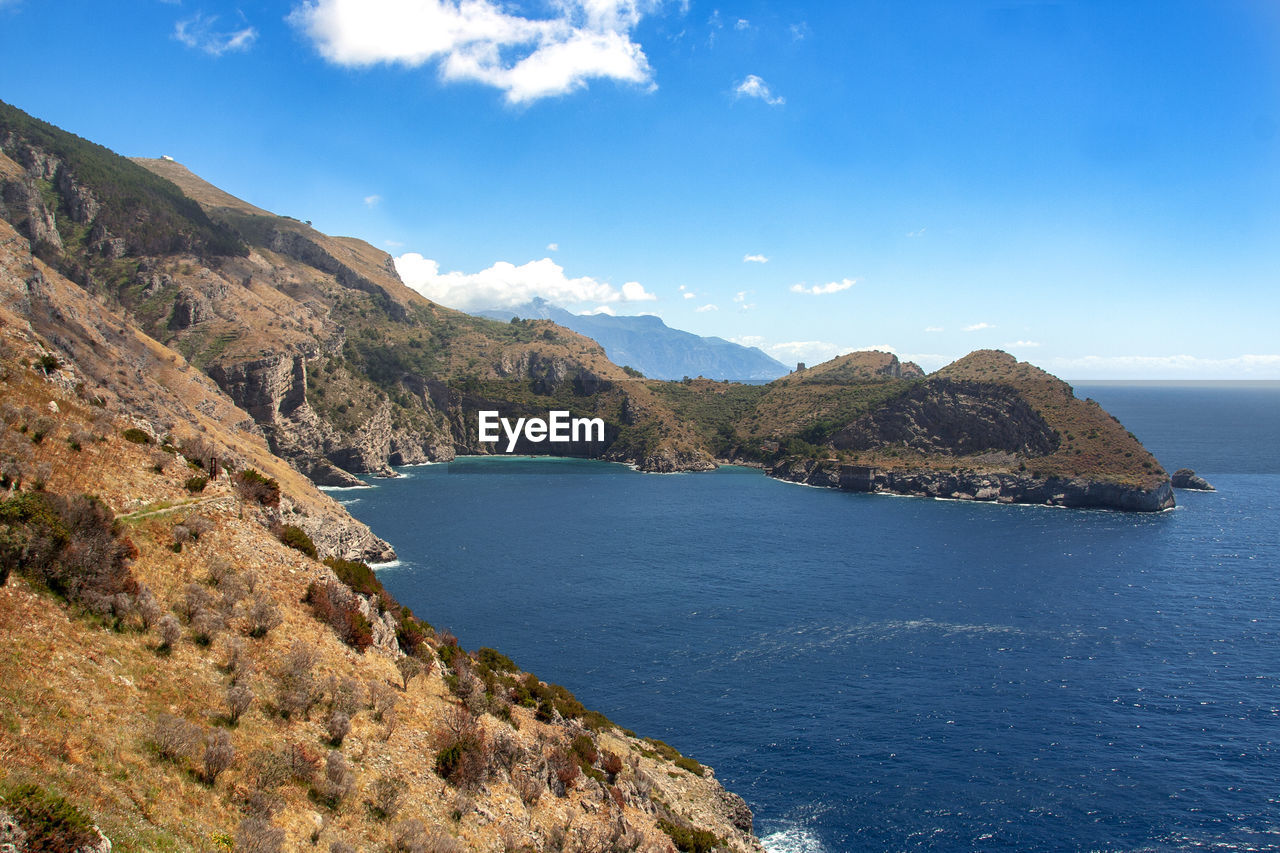 Scenic view of sea and mountains against sky