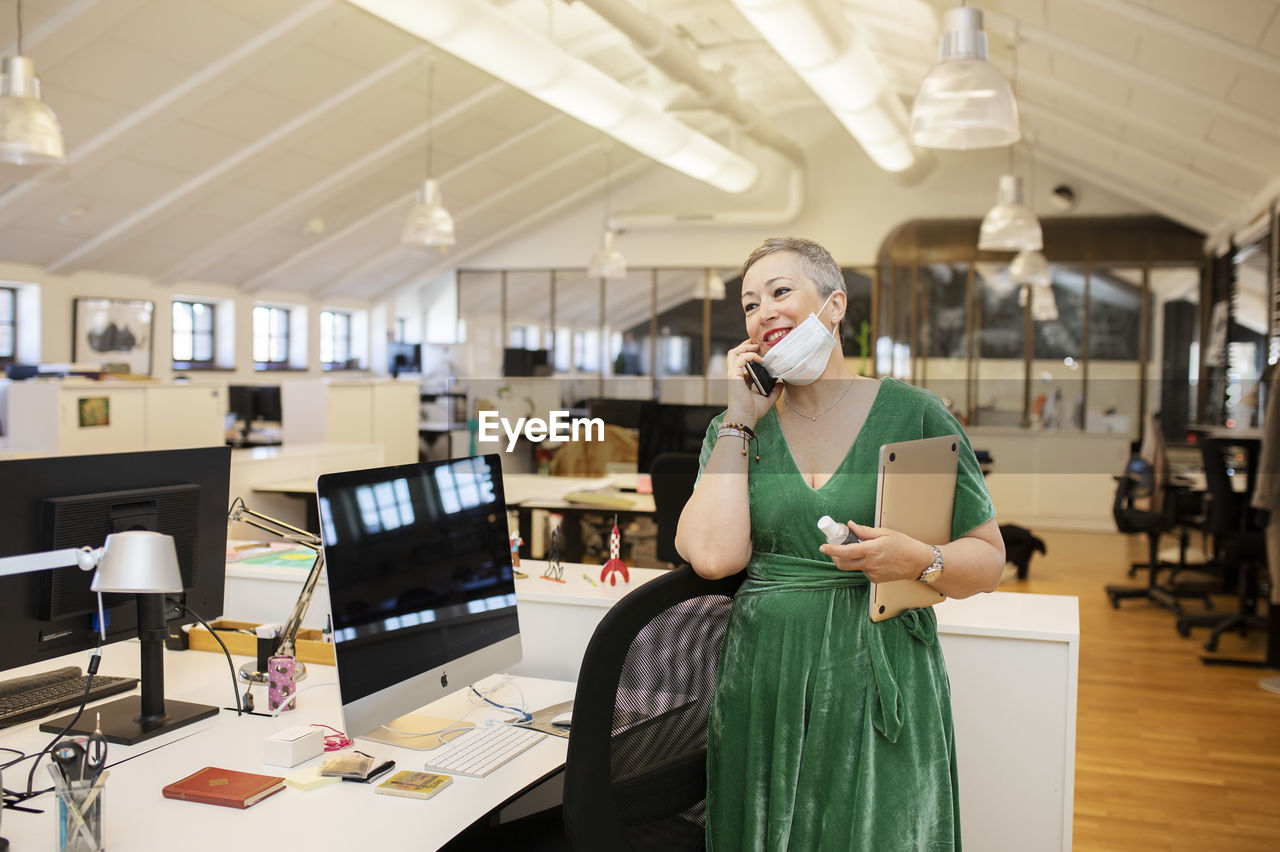 Woman in office talking via cell phone