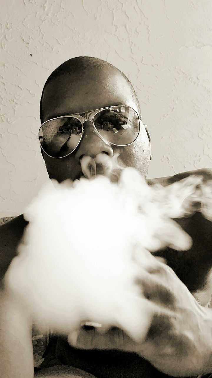 Portrait of man in sunglasses smoking