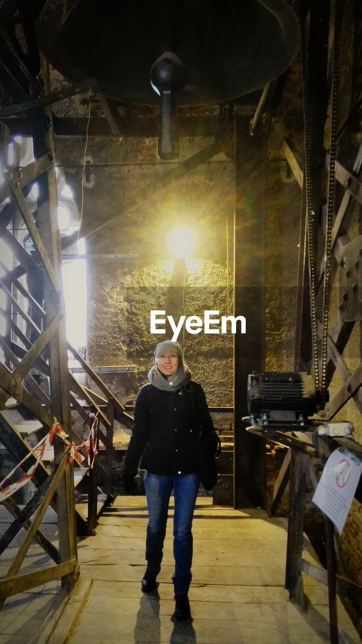 Woman looking at bell while standing in tower