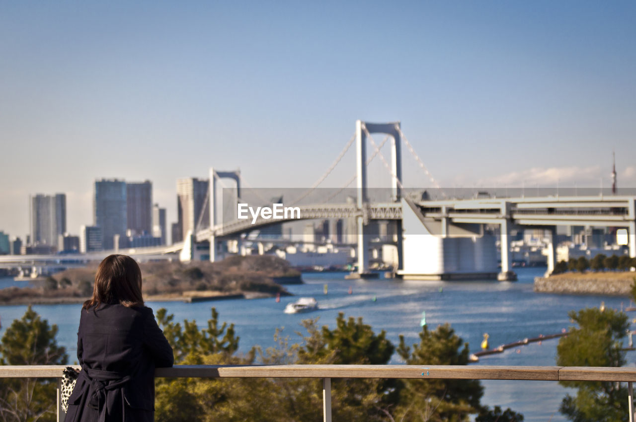 Rear view of woman looking at suspension bridge