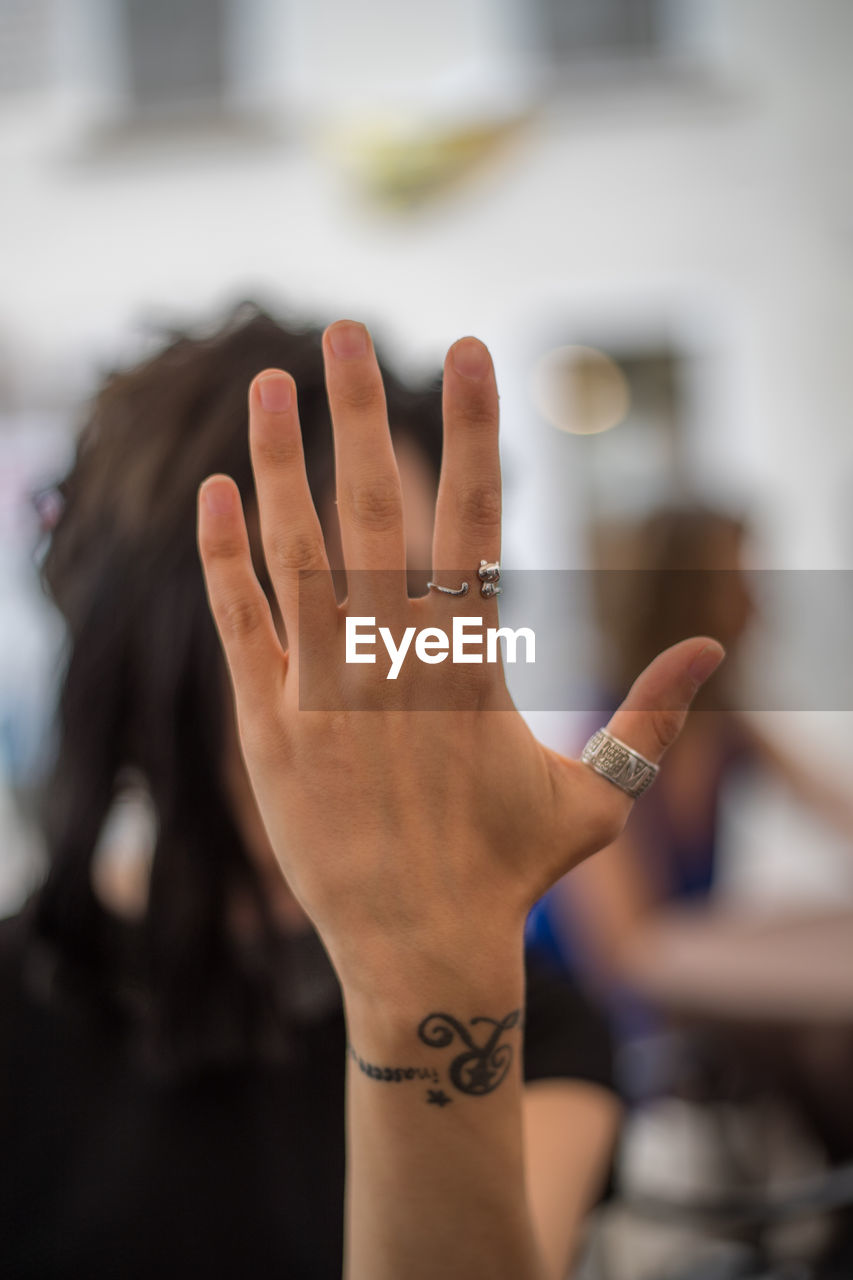 Close-up of woman covering face with hand