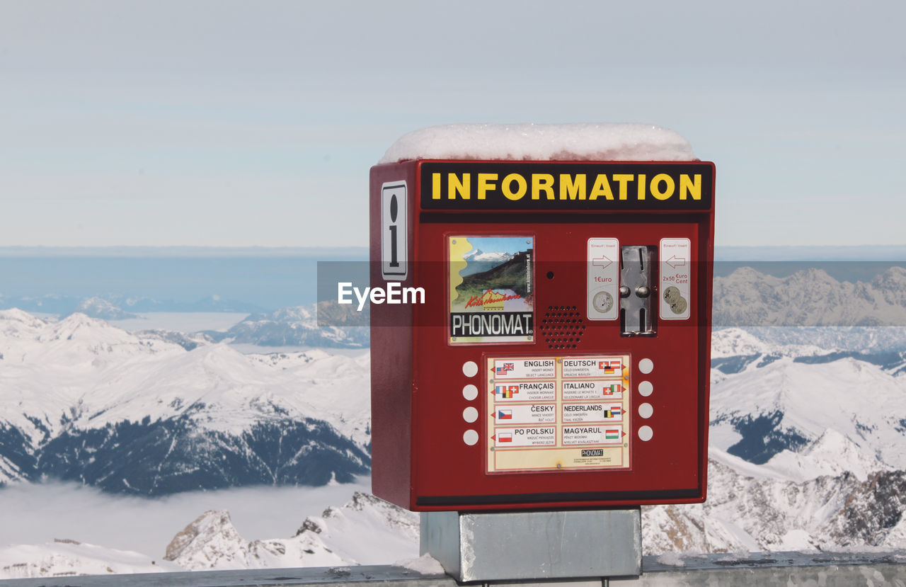 Coin-operated information equipment against snowcapped mountain
