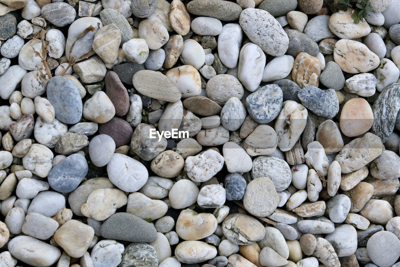 FULL FRAME SHOT OF PEBBLES ON ROCKS