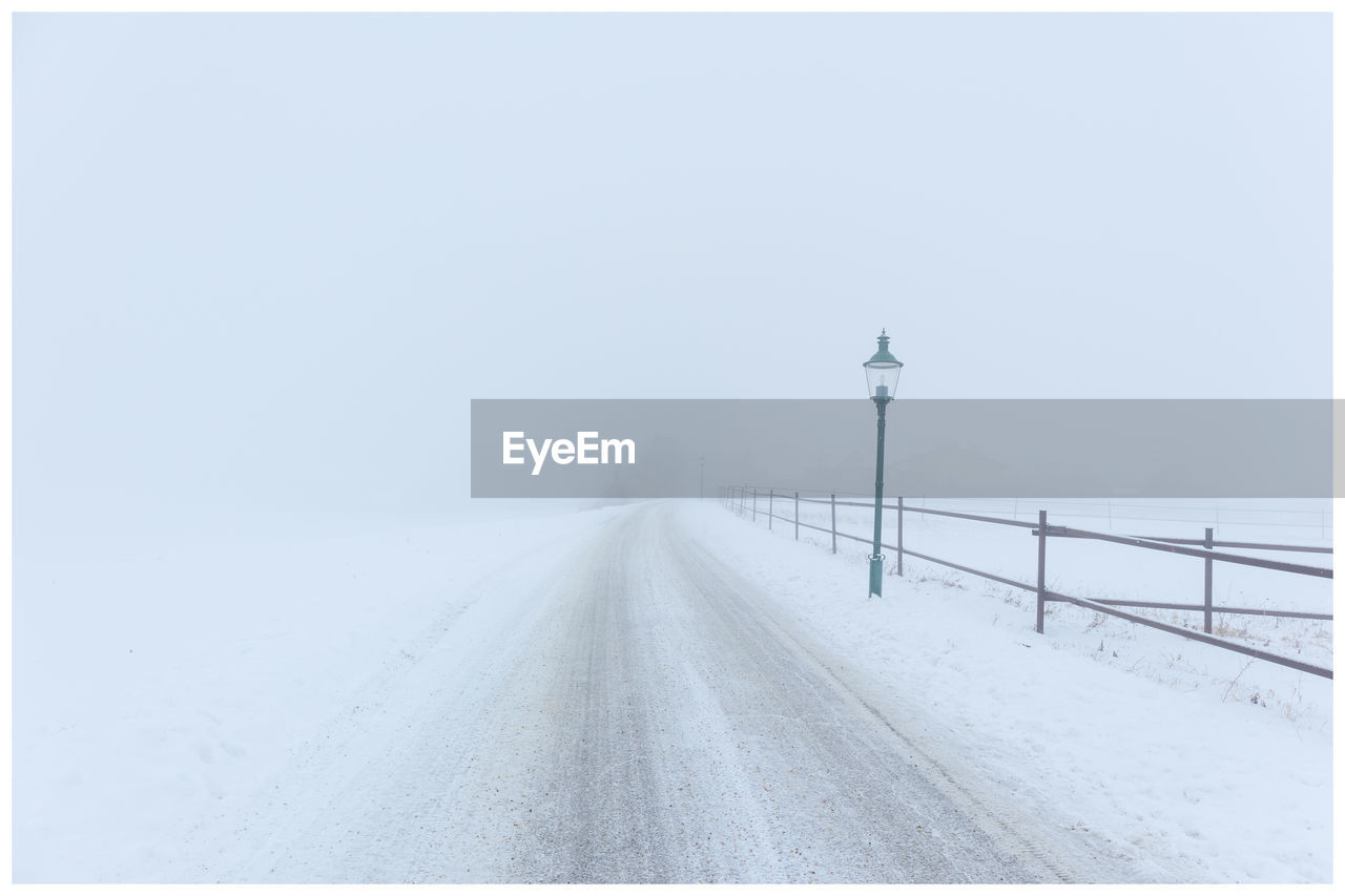 Snow covered landscape against clear sky