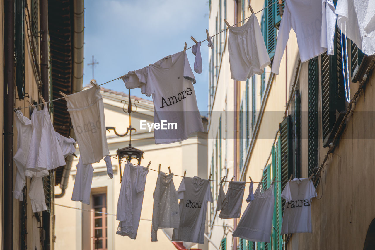 Clothes hung to dry in the sun with various writings in italian love, history, fear