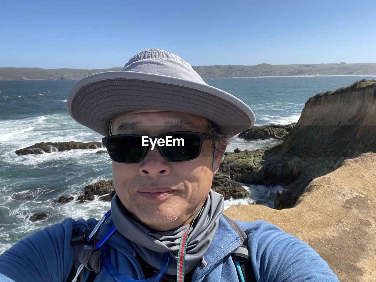 PORTRAIT OF MID ADULT MAN WEARING SUNGLASSES AT SEA