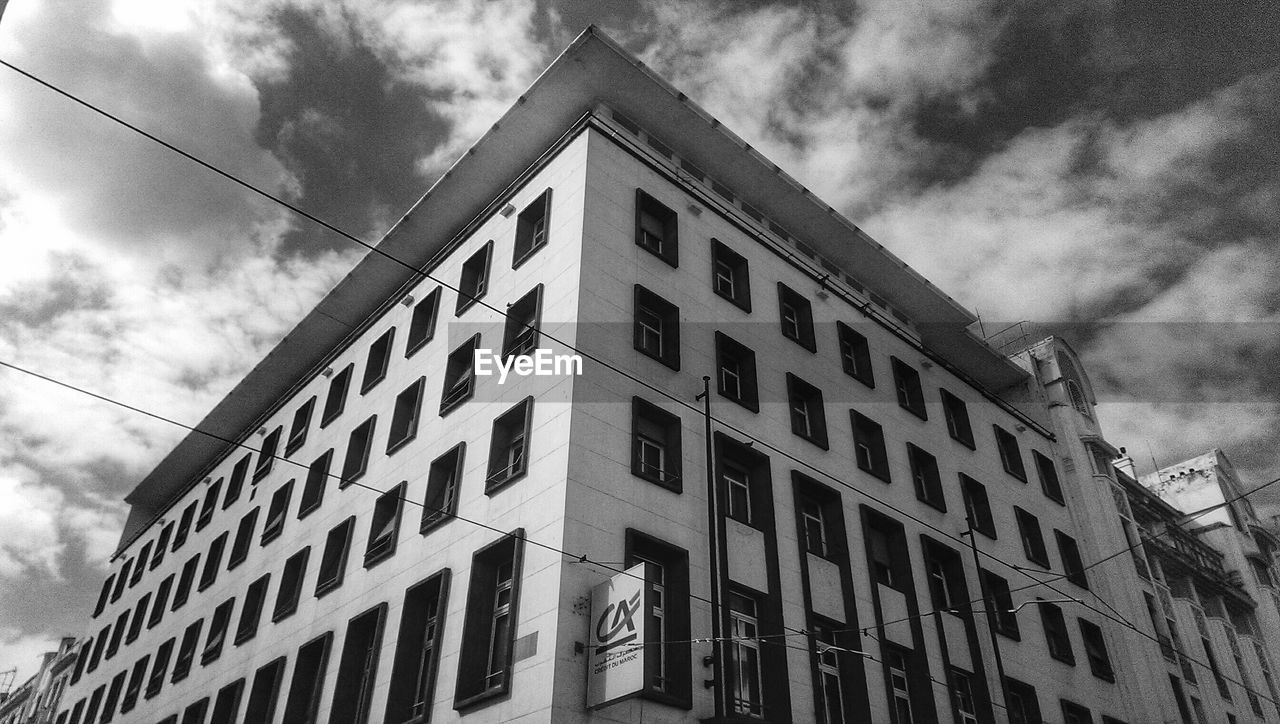 LOW ANGLE VIEW OF BUILDINGS AGAINST CLOUDY SKY