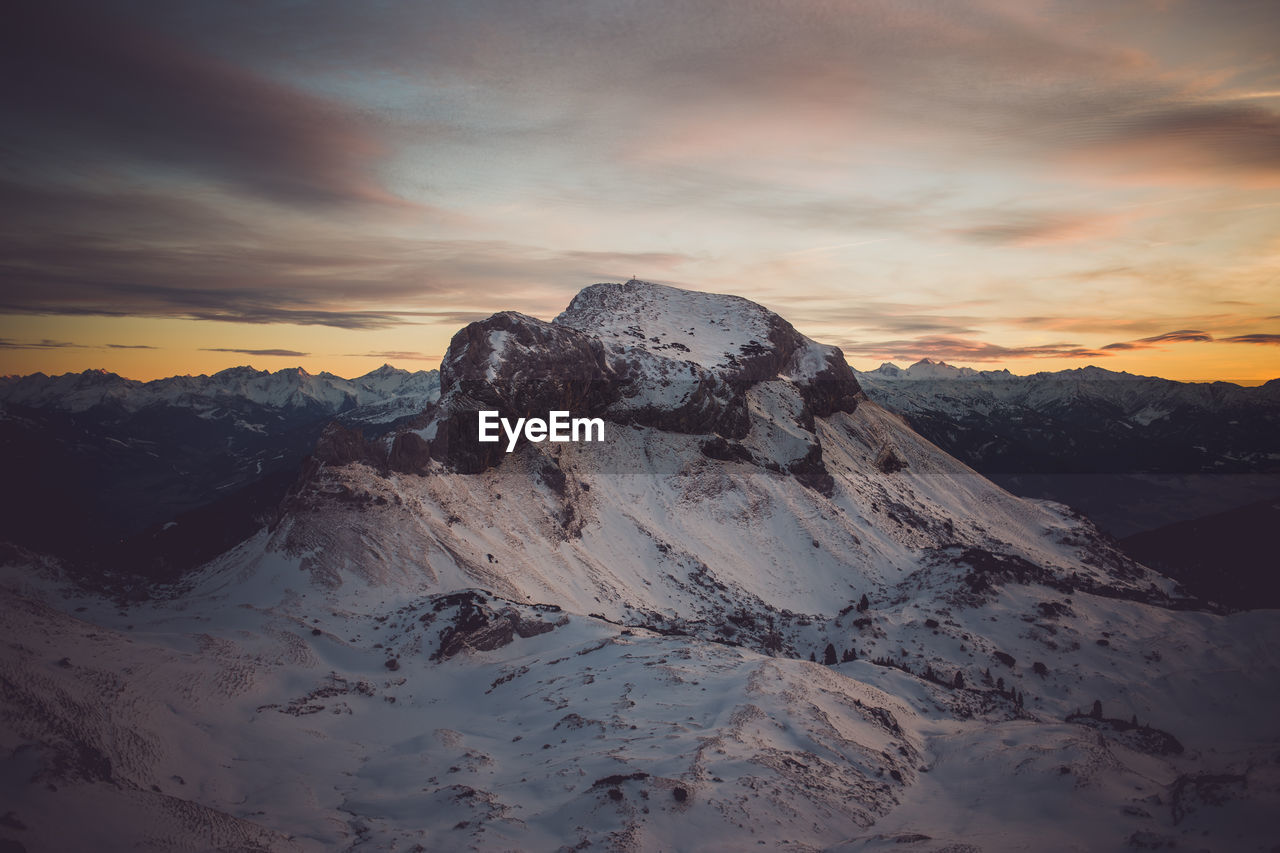 Scenic view of dramatic sky over mountains during sunset