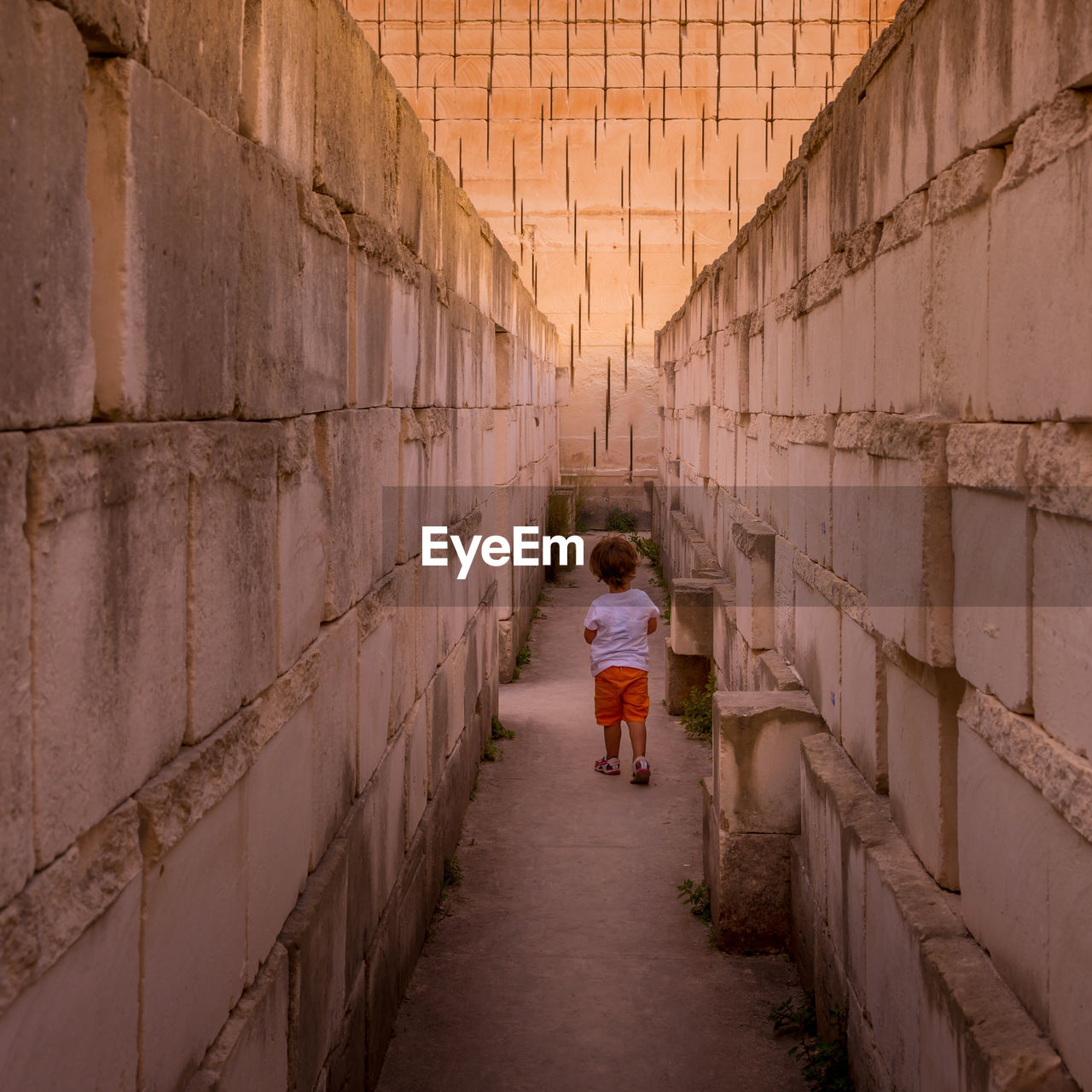 FULL LENGTH REAR VIEW OF WOMAN WALKING ON WALL