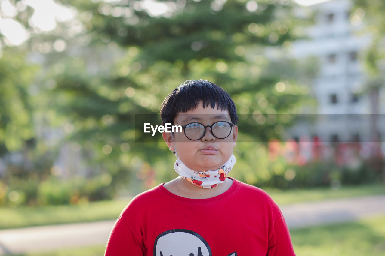 Close-up of boy wearing eyeglasses standing outdoors