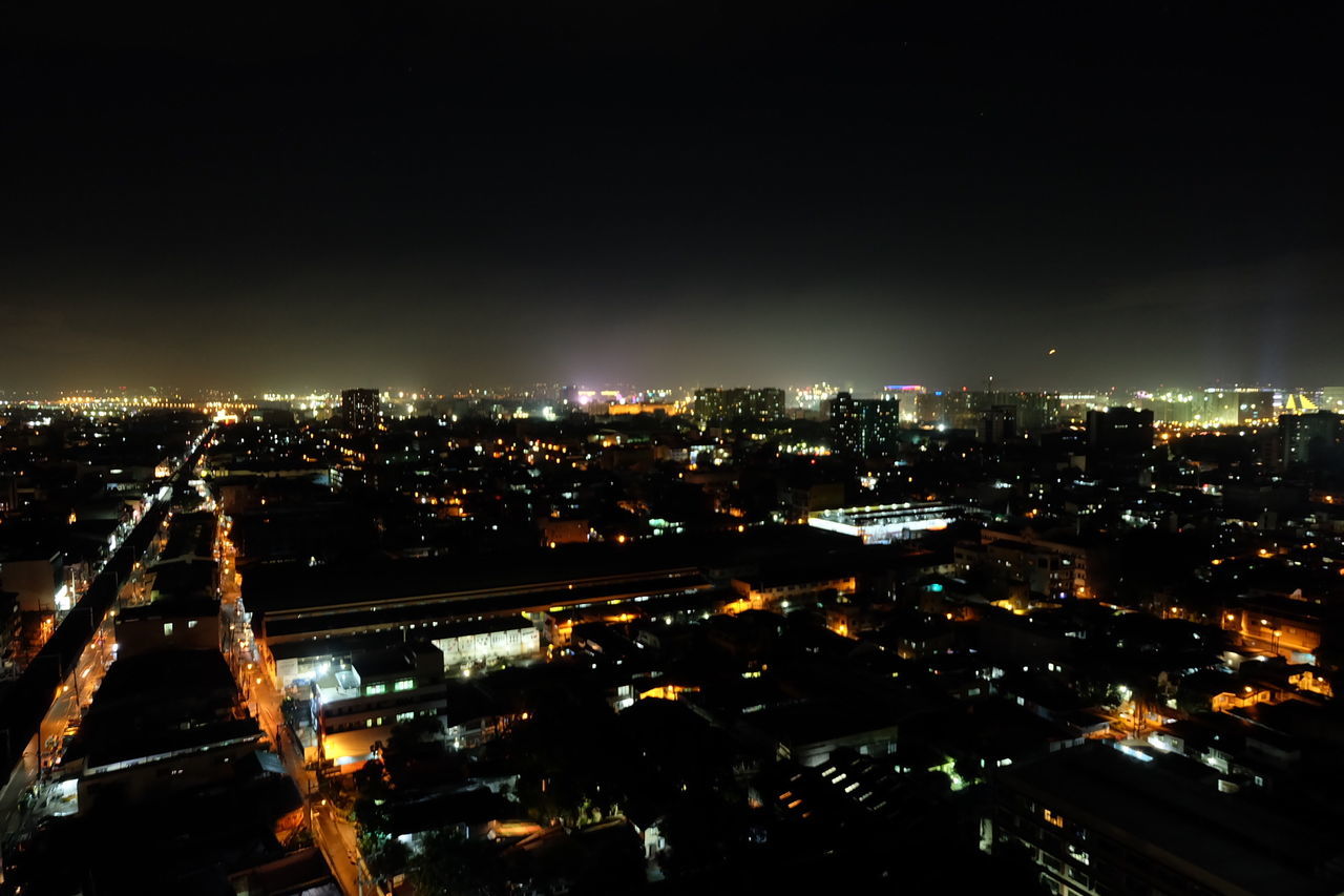 AERIAL VIEW OF ILLUMINATED CITYSCAPE AGAINST SKY