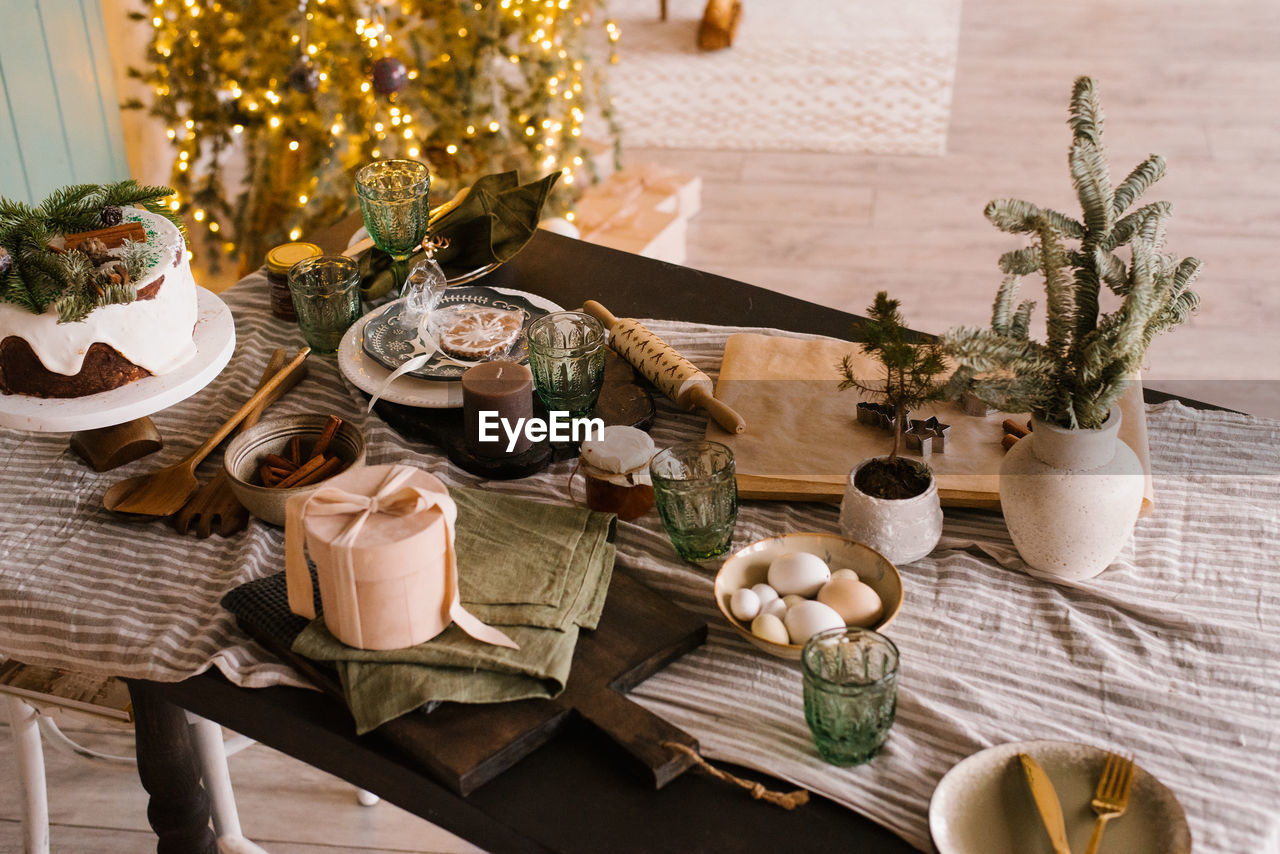 Festive table set for christmas dinner on the background of tree and lights
