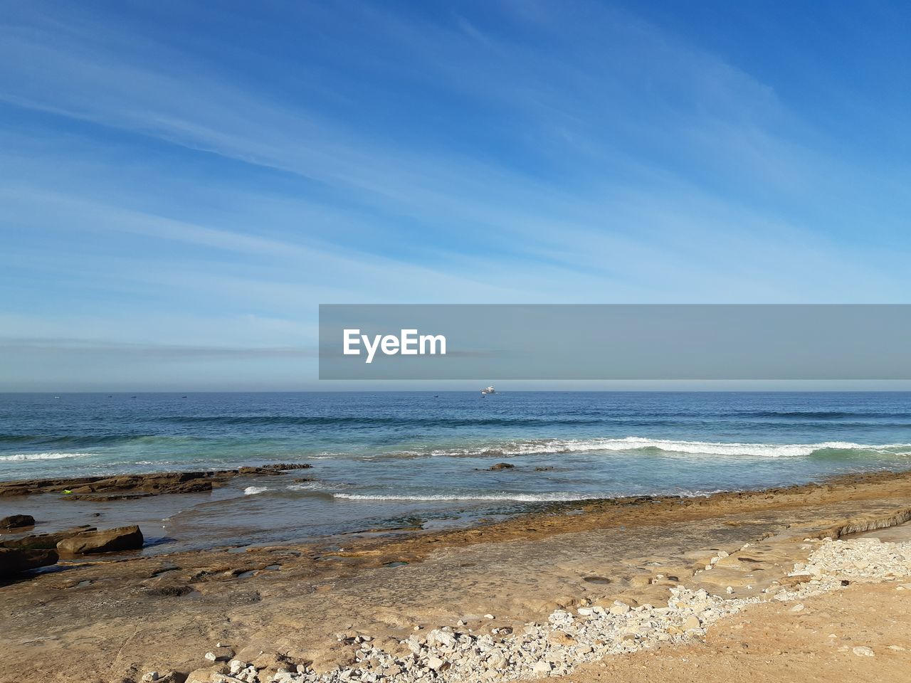 SCENIC VIEW OF BEACH AGAINST BLUE SKY