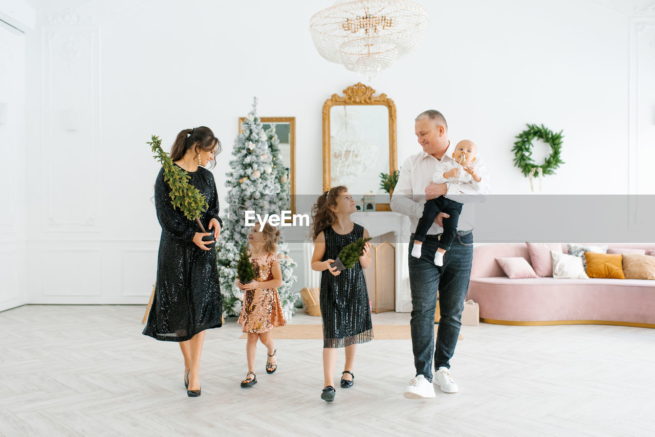 Family with three children is preparing to celebrate christmas. they decorate their house 