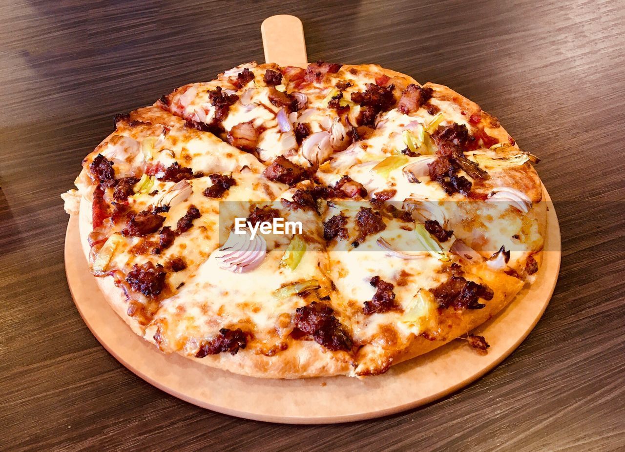 High angle view of pizza served on wooden table