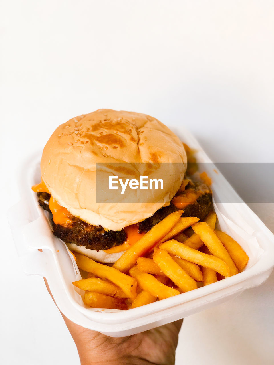 CLOSE-UP OF BURGER ON PLATE AGAINST GRAY BACKGROUND