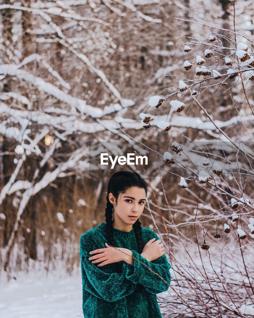 PORTRAIT OF YOUNG WOMAN STANDING AGAINST SNOW