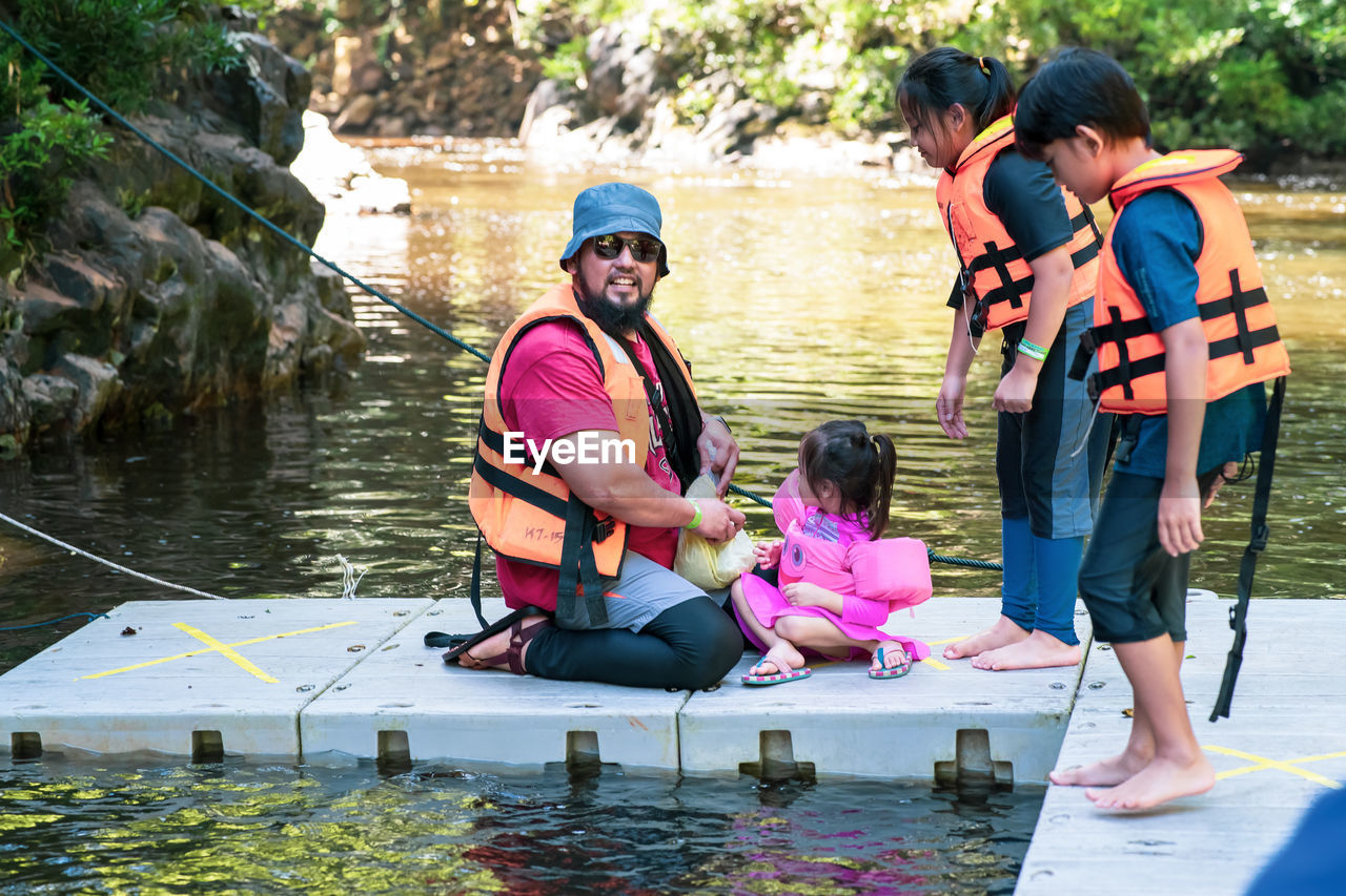 Family feeding fish at the kelah sanctuary in lubuk kejor.