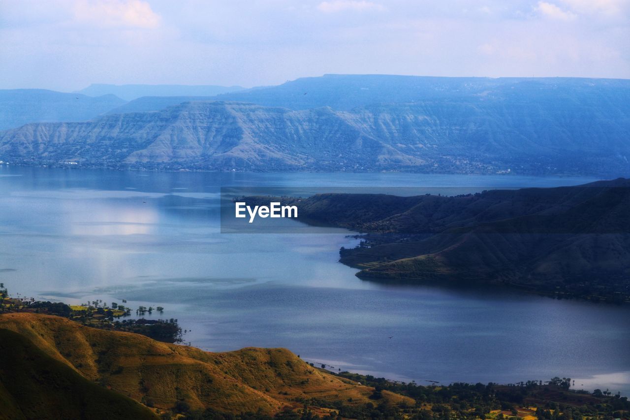 SCENIC VIEW OF MOUNTAINS AND LAKE AGAINST SKY