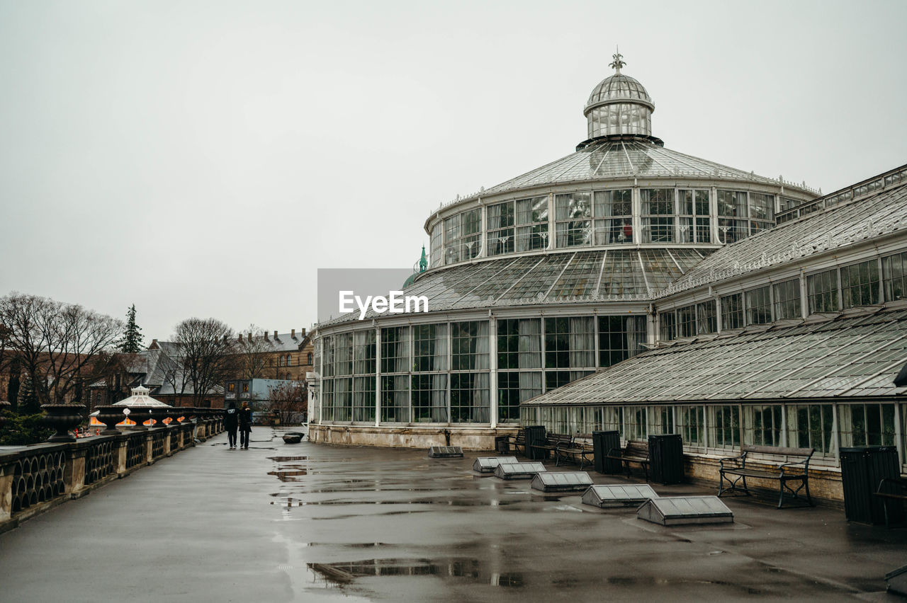 Two people walking amongst botanical garden, copenhagen 