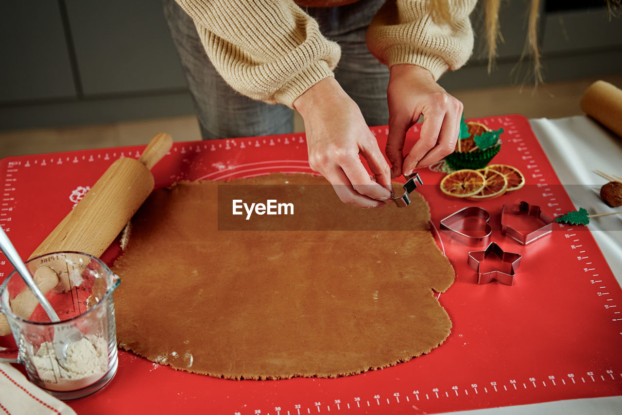 Process of woman making gingerbread cookies at home