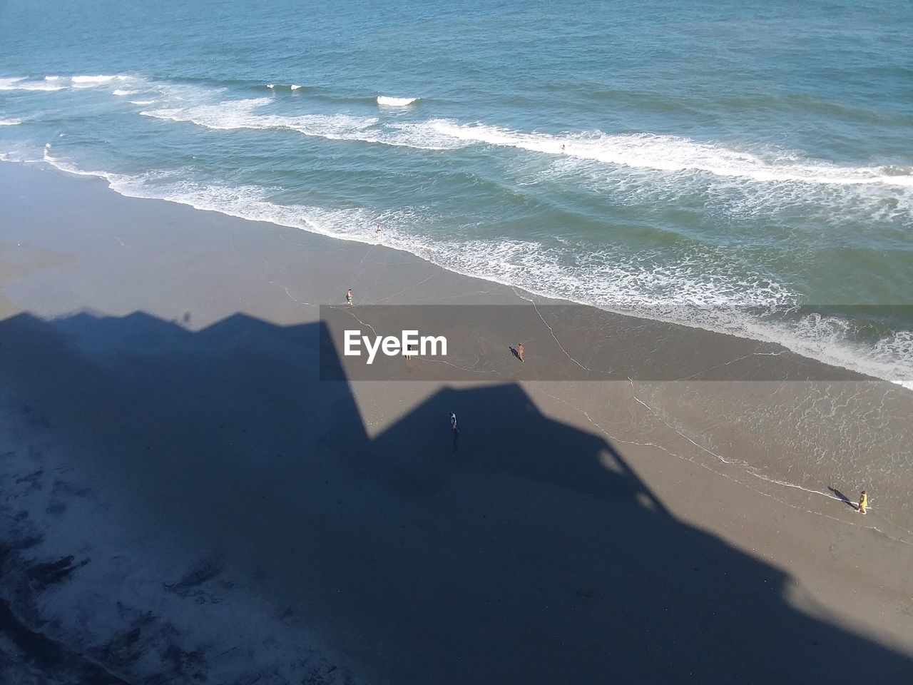 HIGH ANGLE VIEW OF SHADOW ON SHORE AT BEACH