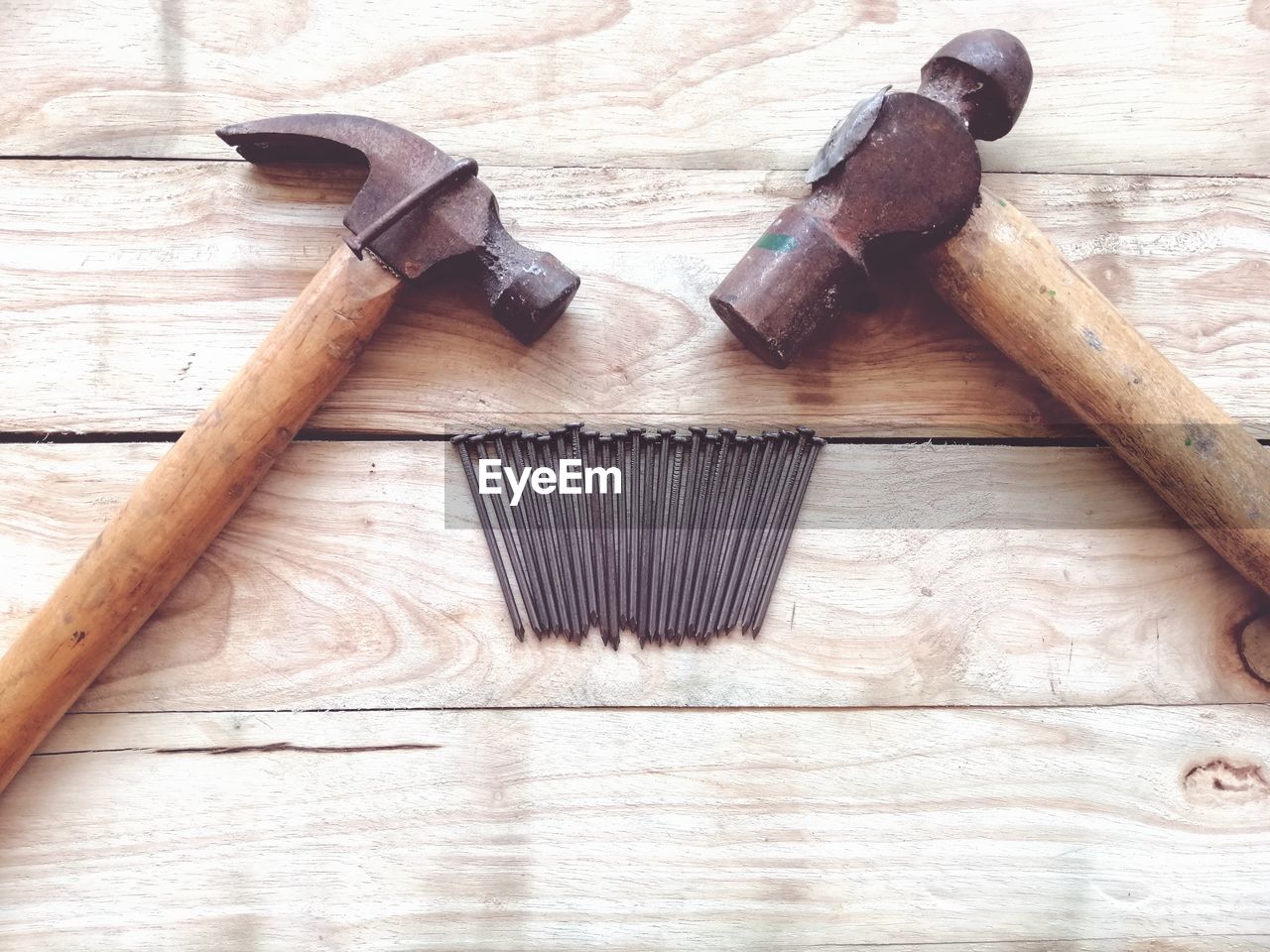 High angle view of nails and hammers on wooden table