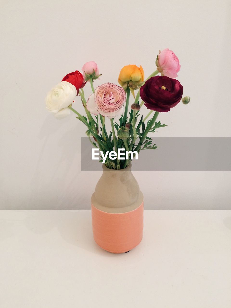Flower vase with fresh flowers on table