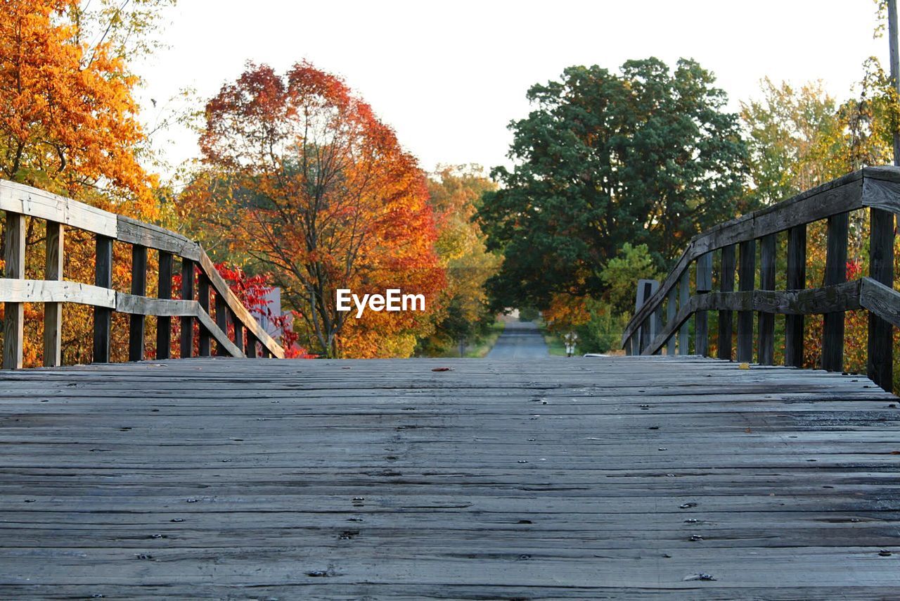 Wooden bridge against autumn trees