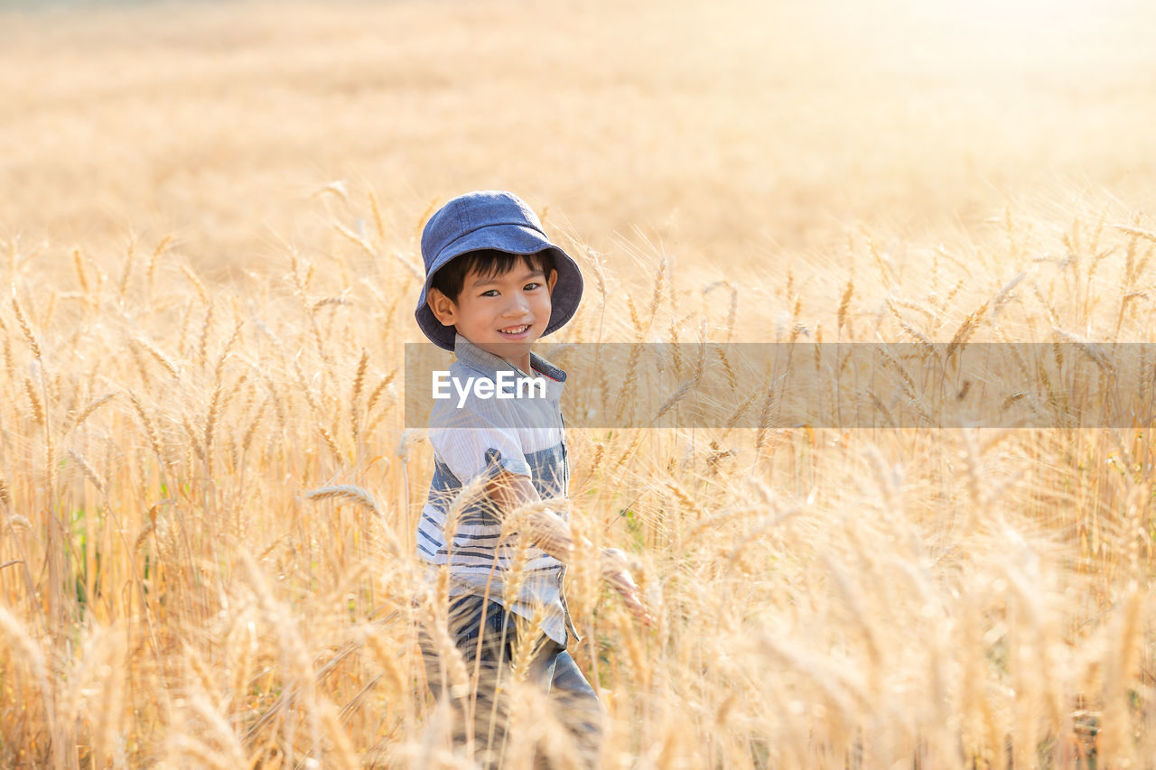 Portrait of smiling boy standing on field