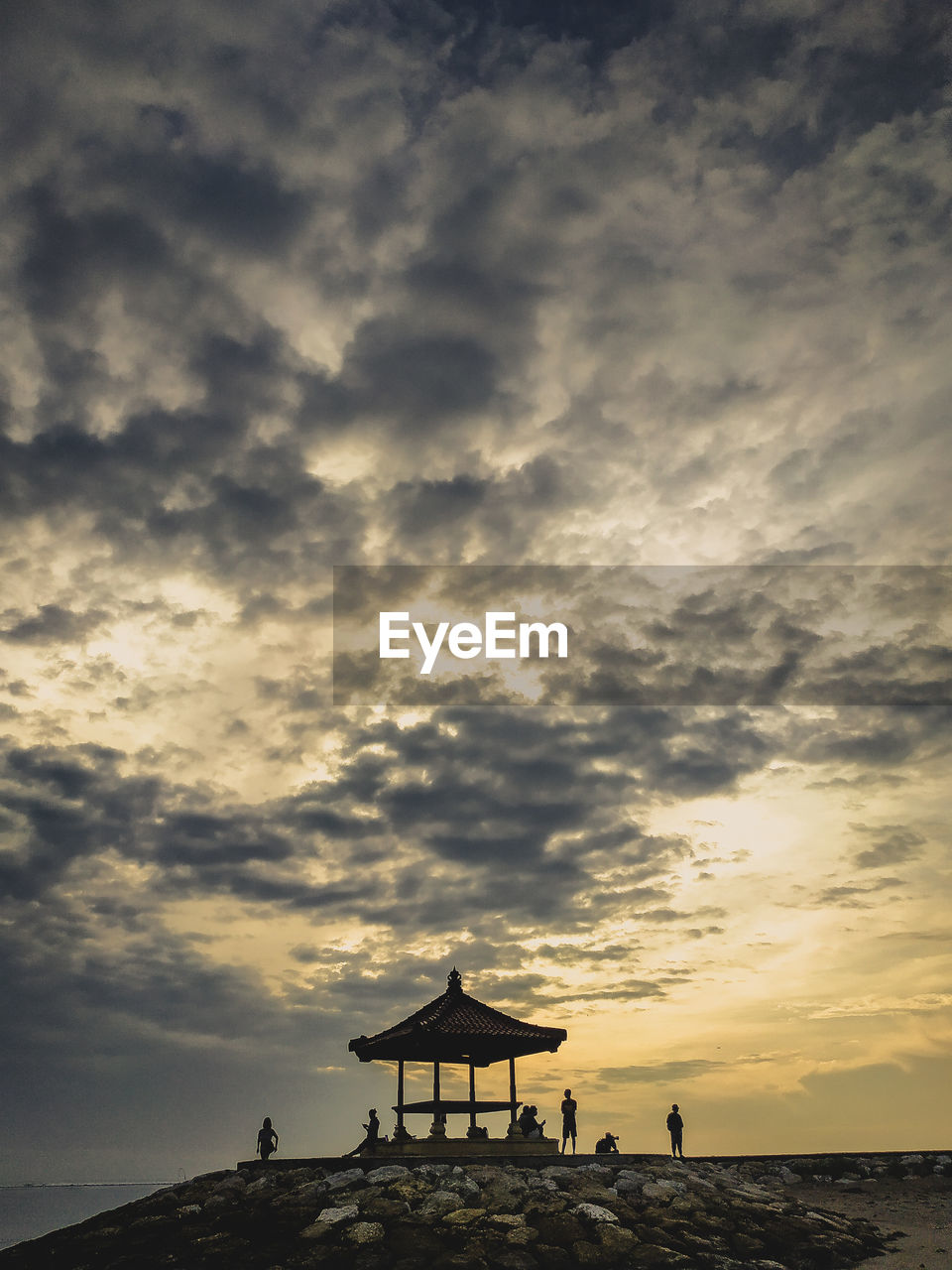 Silhouette lifeguard hut on beach against sky during sunset