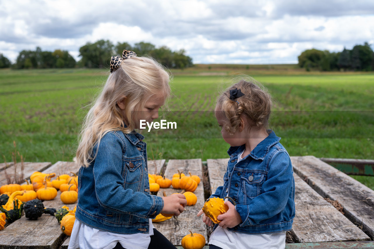 Rear view of mother and daughter in farm