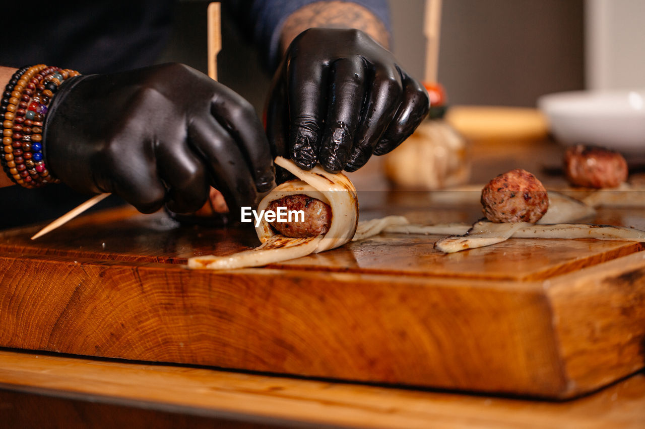 Cropped hand of person preparing food on table