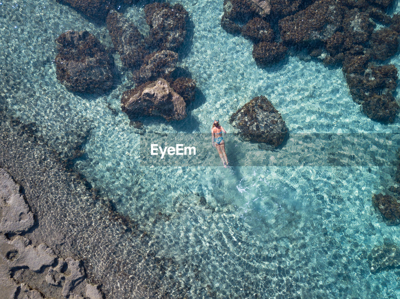 High angle view of woman swimming in sea