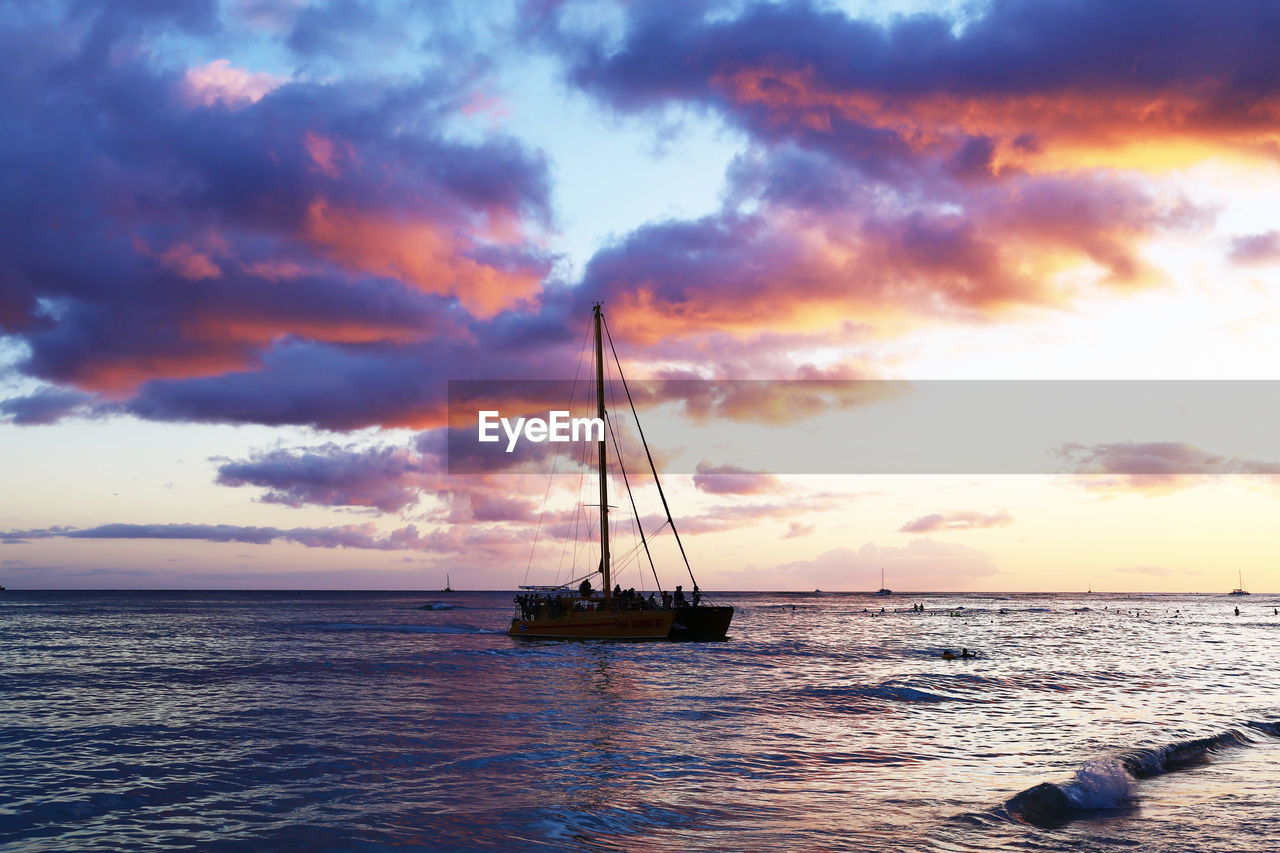 Sailboat in sea against sky during sunset