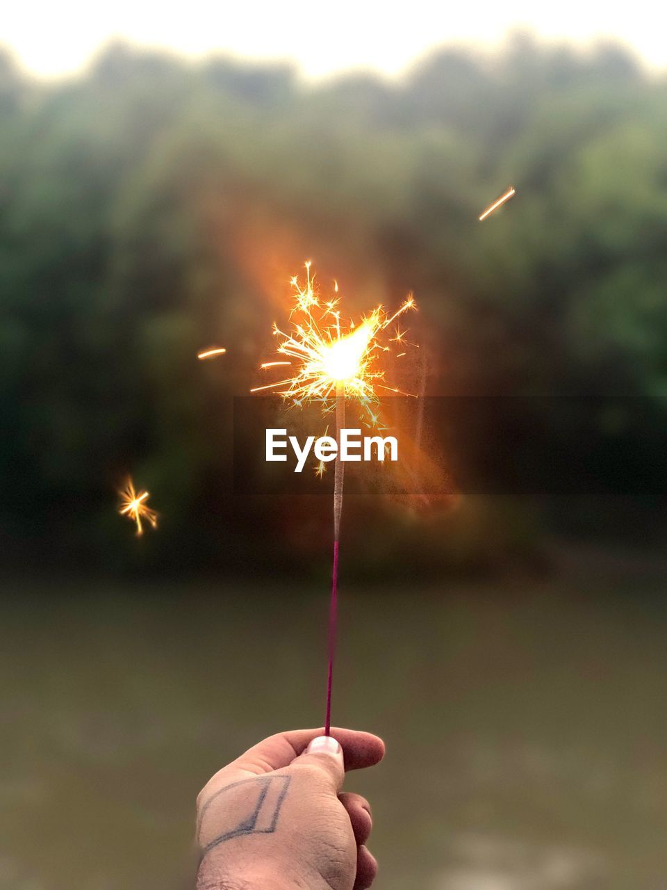 Low angle view of hand holding sparkler 