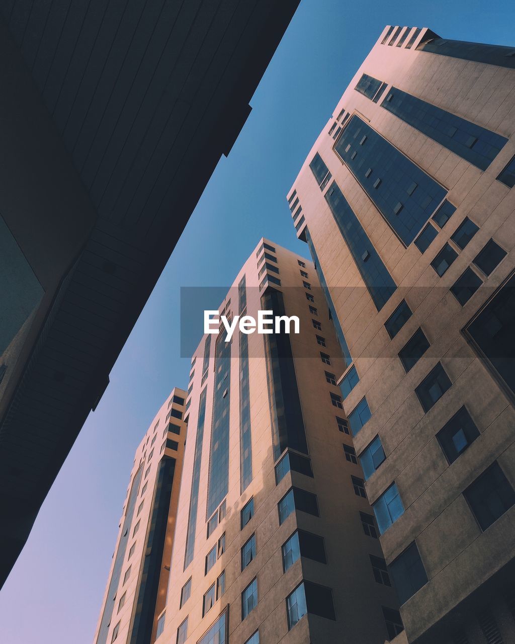 LOW ANGLE VIEW OF MODERN BUILDINGS AGAINST BLUE SKY