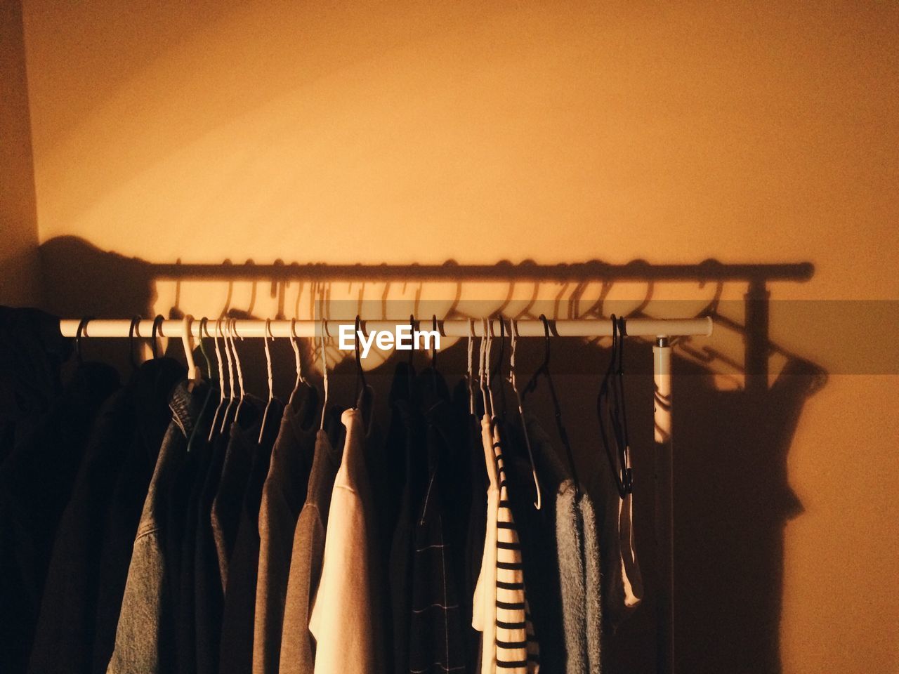 Close-up of clothes hanging in rack against wall