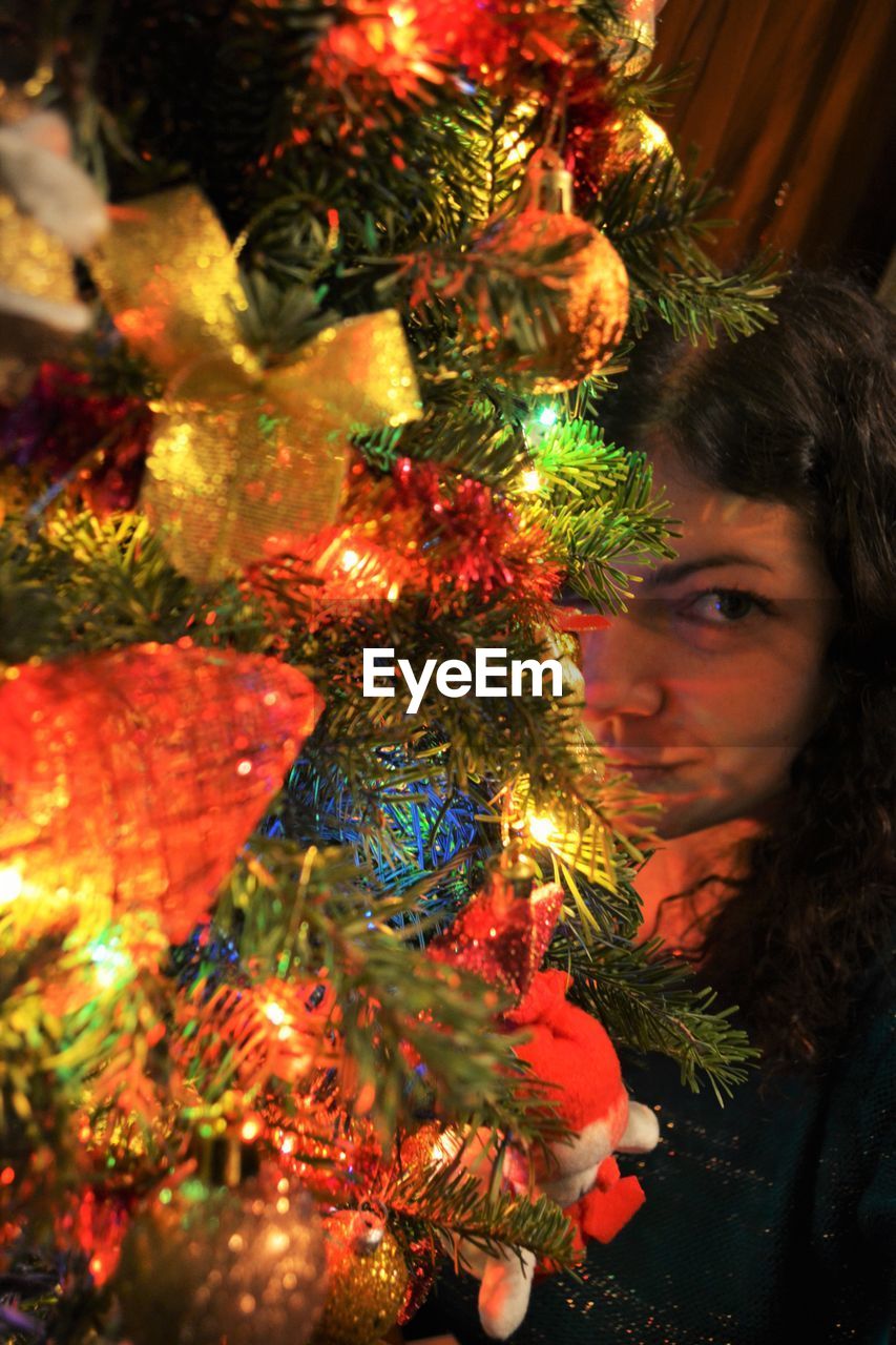 CLOSE-UP PORTRAIT OF SMILING GIRL WITH CHRISTMAS TREE